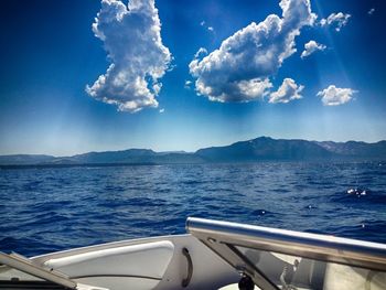 Cropped boat in sea against cloudy sky