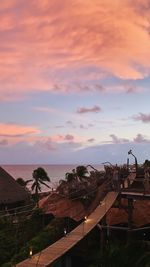 Houses by sea against sky during sunset