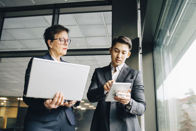 Man and woman using mobile phone in office