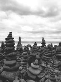 Stack of stones on rocks against sky