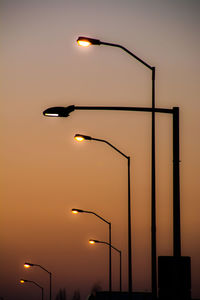 Silhouette street light against sky at dusk