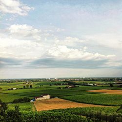 Scenic view of grassy field against cloudy sky