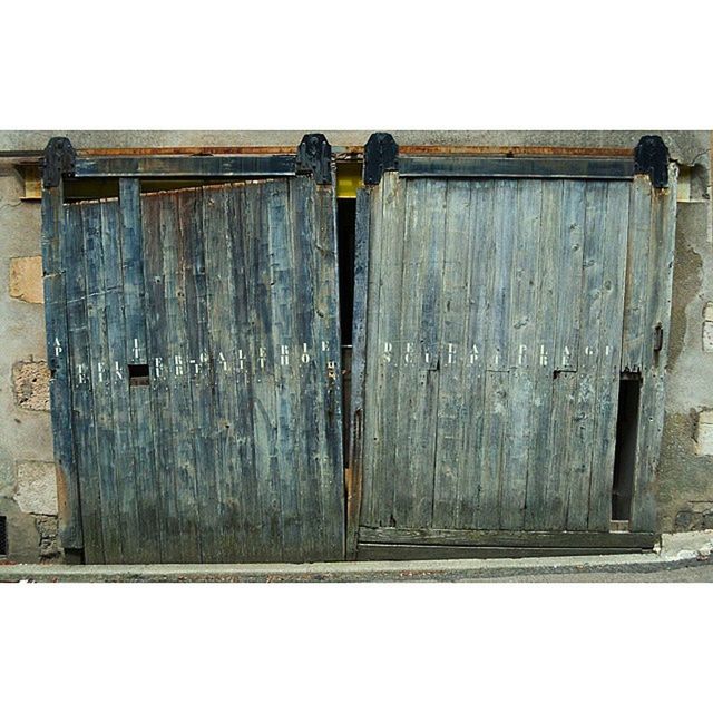 wood - material, wooden, built structure, architecture, building exterior, door, wood, closed, house, safety, protection, wall - building feature, old, security, day, copy space, clear sky, outdoors, wall, weathered