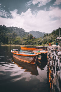 Boat moored in lake against sky