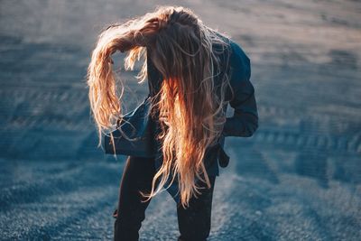 Woman with tousled hair standing outdoors