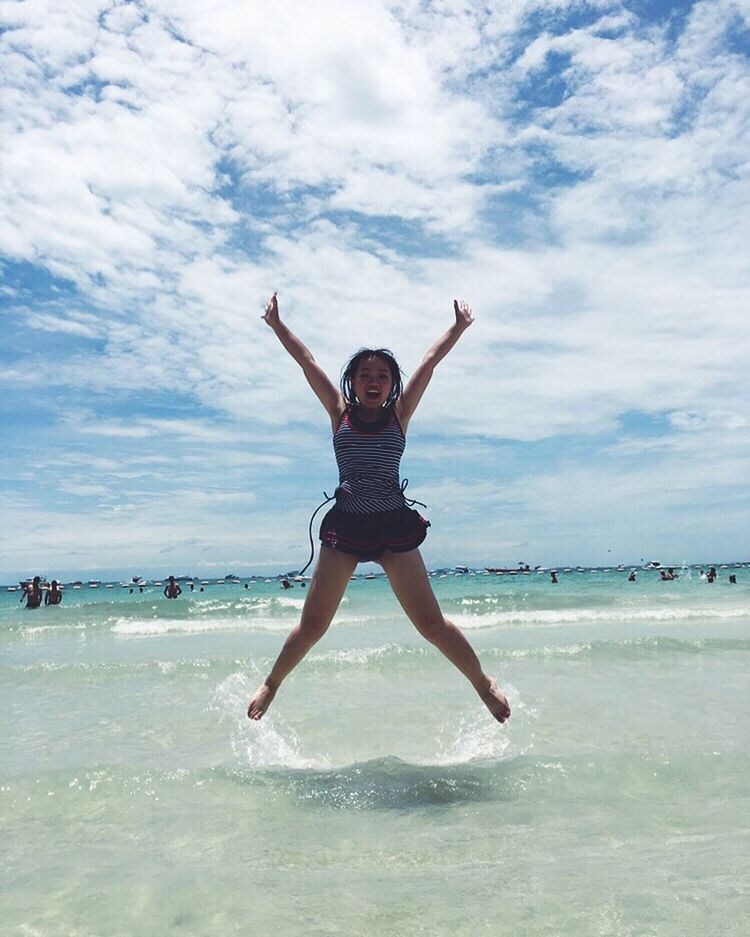 full length, lifestyles, leisure activity, water, sea, jumping, sky, enjoyment, mid-air, fun, arms outstretched, vacations, young adult, arms raised, beach, freedom, cloud - sky, carefree