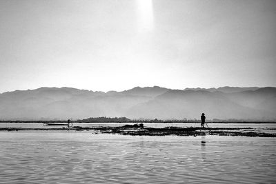 Man standing in sea against clear sky