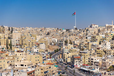 Jordan flag in amman, cityscape view