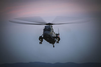 Low angle view of helicopter flying against sky