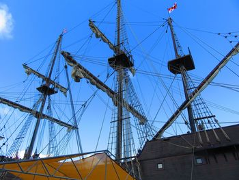 Low angle view of sailboat sailing on harbor against blue sky