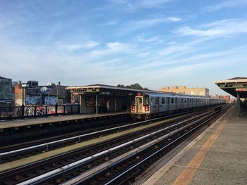 Railroad tracks in city against sky