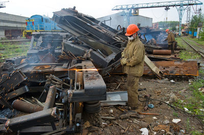 Worker welding scrap metal