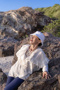 Portrait of a happy mature woman smiling outdoors. happy smiling mature woman on the rock 