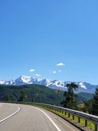 Road by mountain against blue sky