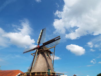 Low angle view of traditional windmill against blue sky