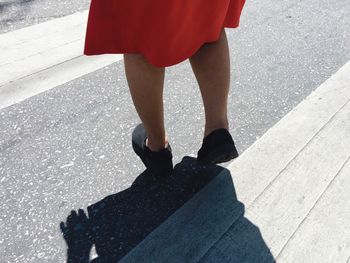 Low section of woman standing on road