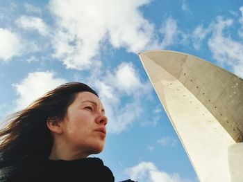 Low angle view of woman looking up against sky