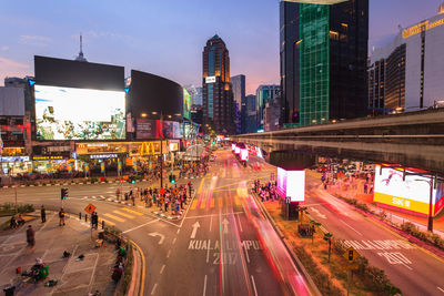 Vehicles on city street amidst buildings at night