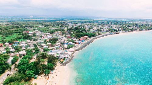 High angle view of sea and cityscape against sky