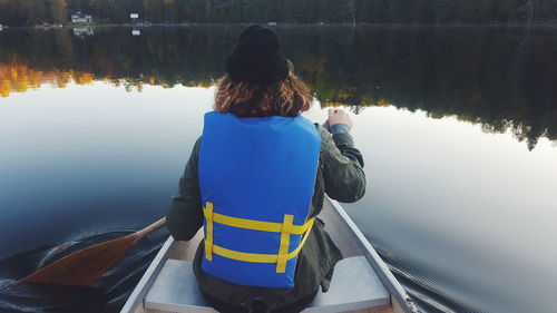 Rear view of man on boat in lake