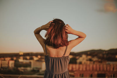 Rear view of woman standing against clear sky