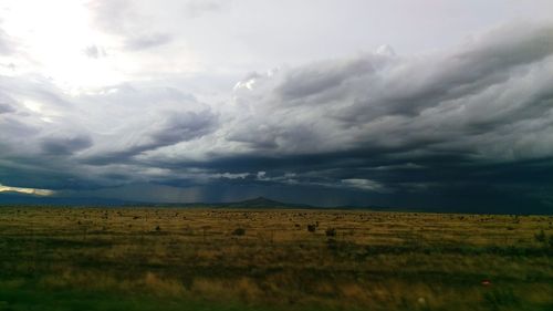 Scenic view of field against cloudy sky