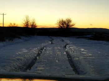 Snow covered landscape at sunset