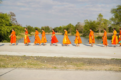 Group of people walking on road against sky