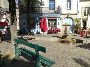 View of empty chairs on street against buildings