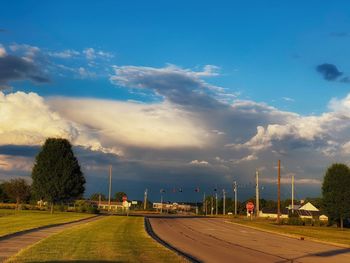 Road by trees against sky