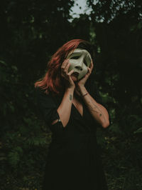 Full length of woman standing by tree