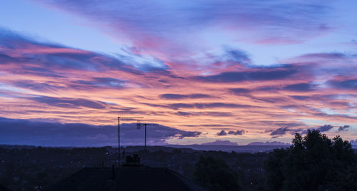 Silhouette roof against sky during sunset