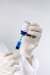 Midsection of doctor holding syringe and vial