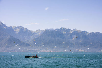 Scenic view of sea and mountains against sky