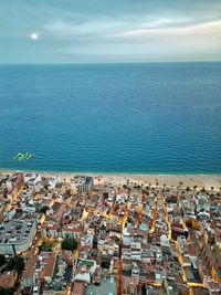 High angle view of townscape by sea against sky