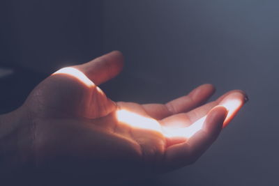 Sunlight falling on hand against wall