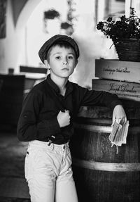 Portrait of young woman standing against wall