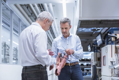 Two managers discussing construction of an prostethic leg