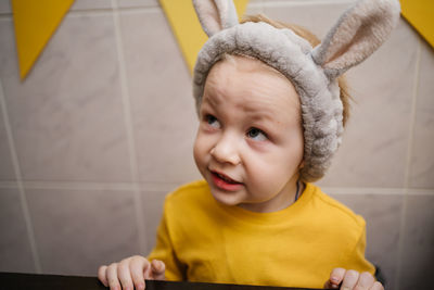 Portrait of a baby in rabbit ears easter yellow clothes. high quality photo