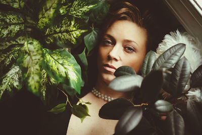 Portrait of young woman with leaves and plants in winter