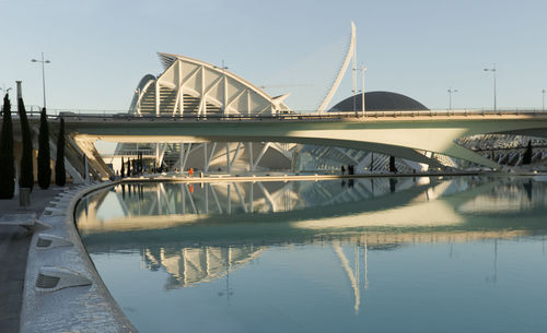 Bridge over river in city against sky