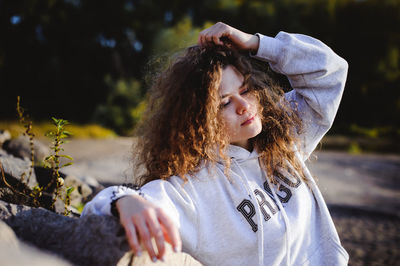 Close-up of young woman with hand in hair