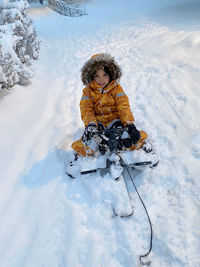 Portrait of  boy sitting in a sledge during winter