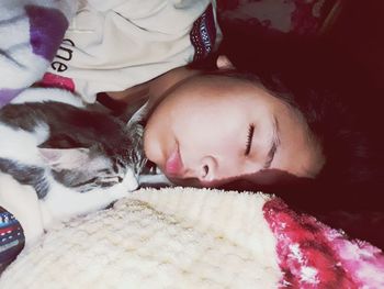 Young woman sleeping with dog on bed