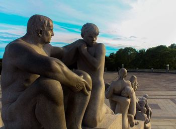 Statues sitting against sky