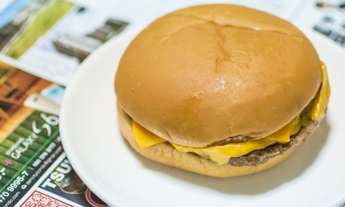 Close-up of cheese hamburger served in plate on table