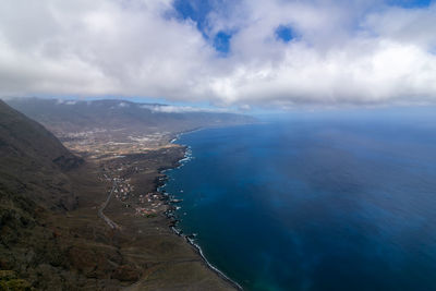 Aerial view of sea and mountains against sky