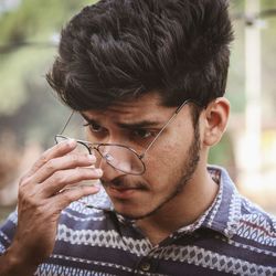 Close-up of thoughtful young man wearing eyeglasses