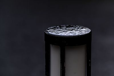 Close-up of water drops on metal against black background
