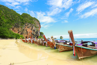 Boats moored on beach against sky